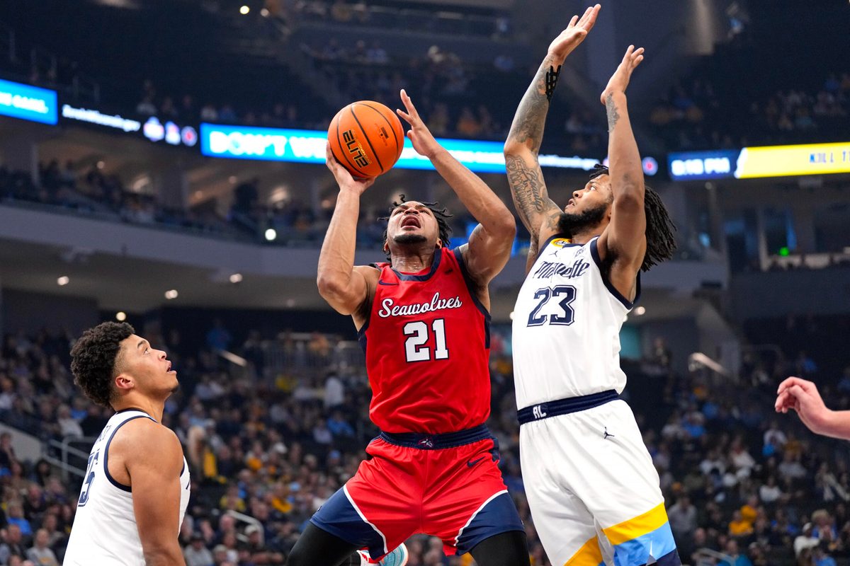 Nov 4, 2024; Milwaukee, Wisconsin, USA; Stony Brook Seawolves guard-forward Andre Snoddy (21) shoots around Marquette Golden Eagles forward David Joplin (23) during the first half at Fiserv Forum. Mandatory Credit: Jeff Hanisch-Imagn Images