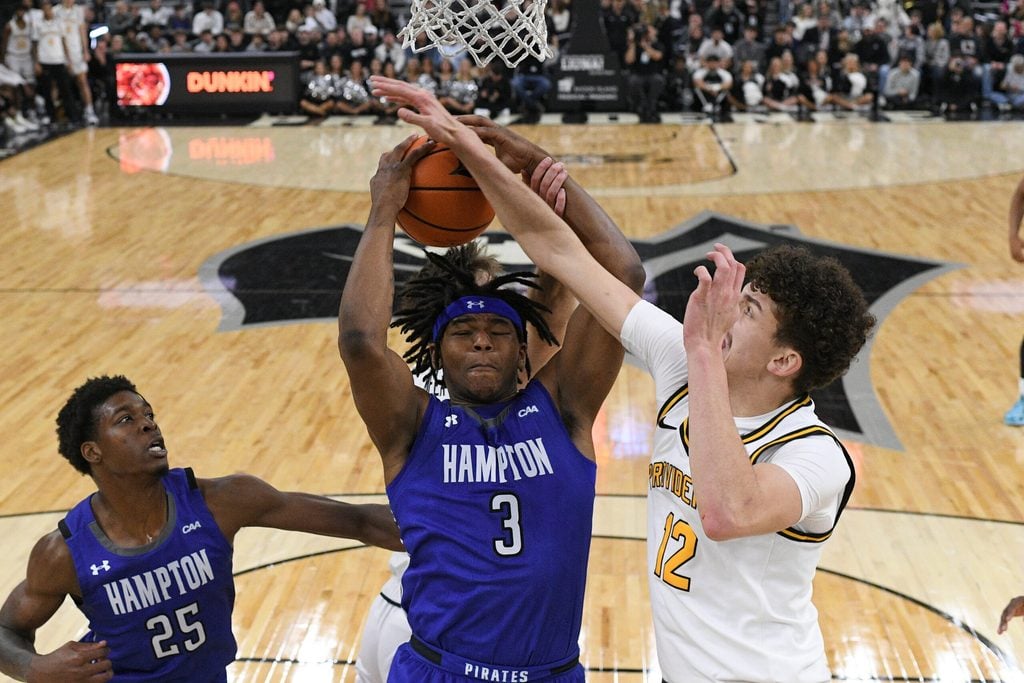 Nov 12, 2024; Providence, Rhode Island, USA; Providence Friars forward Eli DeLaurier (12) defends against Hampton Pirates forward Kyrese Mullen (3) during the second half at Amica Mutual Pavilion. Mandatory Credit: Eric Canha-Imagn Images