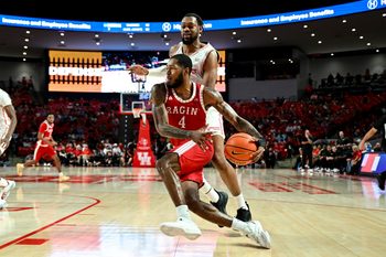 Nov 13, 2024; Houston, Texas, USA; Louisiana Ragin Cajuns guard Kyndall Davis (4) drives past Houston Cougars forward J'Wan Roberts (13) during the second half at Fertitta Center. The Cougars defeated the Ragin Cajuns 91-45. Mandatory Credit: Maria Lysaker-Imagn Images