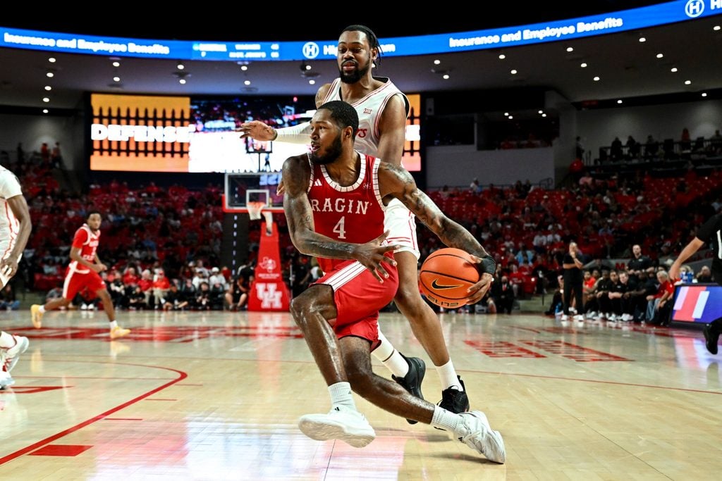Nov 13, 2024; Houston, Texas, USA; Louisiana Ragin Cajuns guard Kyndall Davis (4) drives past Houston Cougars forward J'Wan Roberts (13) during the second half at Fertitta Center. The Cougars defeated the Ragin Cajuns 91-45. Mandatory Credit: Maria Lysaker-Imagn Images