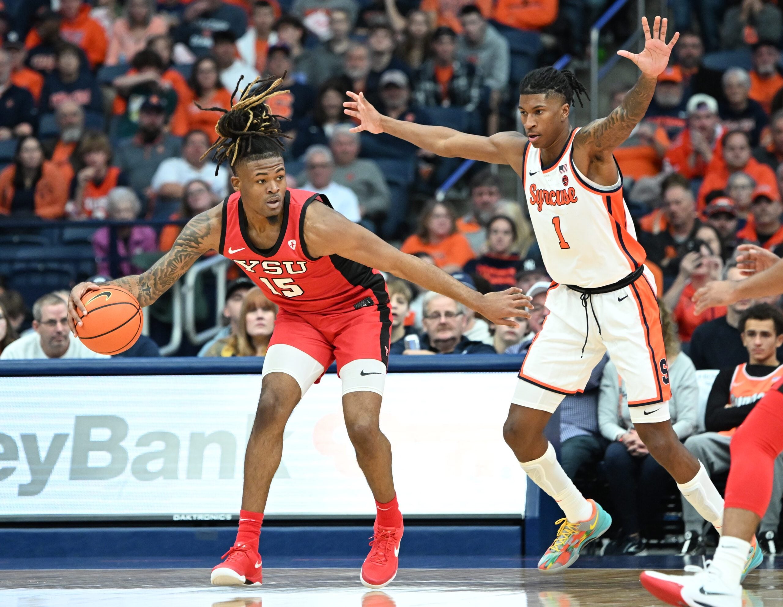 Nov 16, 2024; Syracuse, New York, USA; Youngstown State Penguins forward Cris Carroll (15) tries to move past Syracuse Orange forward Donnie Freeman (1) in the second half at the JMA Wireless Dome. Mandatory Credit: Mark Konezny-Imagn Images