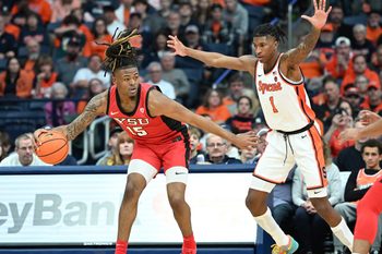 Nov 16, 2024; Syracuse, New York, USA; Youngstown State Penguins forward Cris Carroll (15) tries to move past Syracuse Orange forward Donnie Freeman (1) in the second half at the JMA Wireless Dome. Mandatory Credit: Mark Konezny-Imagn Images