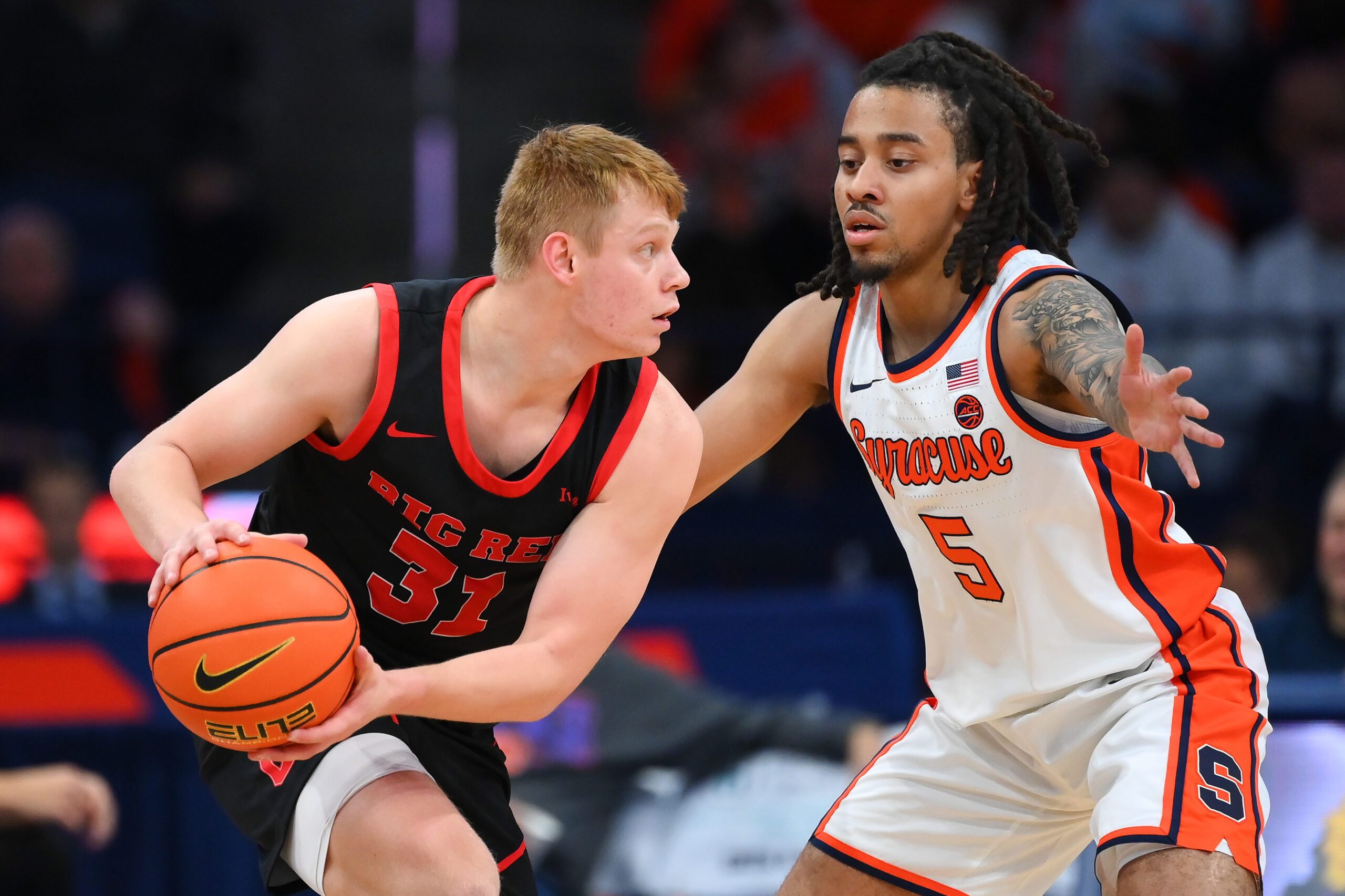 Nov 27, 2024; Syracuse, New York, USA; Cornell Big Red guard Cooper Noard (31) controls the ball as Syracuse Orange guard Jaquan Carlos (5) defends during the second half at the JMA Wireless Dome. Mandatory Credit: Rich Barnes-Imagn Images