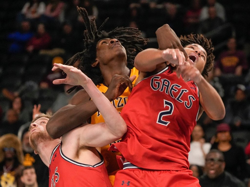 Jaydan Quaintance, 21, of Arizona State University holds down and rebounds the ball against Saint Mary's College defenders Jordan Ross, 2, and Augustas Marciulionis, 3, during the 2024 Acrisure Men's Classic in Palm Desert, Calif., Nov. 29, 2024.