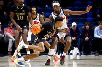 Dec 7, 2024; Oxford, Mississippi, USA; Lindenwood Lions guard Anias Futrell (12) dribbles the ball against Mississippi Rebels guard Davon Barnes (7) during the first half at The Sandy and John Black Pavilion at Ole Miss. Mandatory Credit: Petre Thomas-Imagn Images