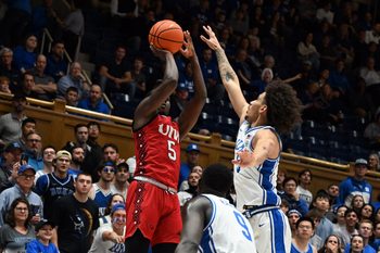 Dec 10, 2024; Durham, North Carolina, USA;  dIncarnate Word Cardinals guard Davion Bailey (5) shoots over Duke Blue Devils guard Tyrese Proctor (5) uring the first half at Cameron Indoor Stadium. Mandatory Credit: Rob Kinnan-Imagn Images