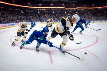 Dec 14, 2024; Vancouver, British Columbia, CAN; Boston Bruins defenseman Charlie McAvoy (73) watches as Vancouver Canucks forward Conor Garland (8) stick checks  defenseman Nikita Zadorov (91) during the second period at Rogers Arena. Mandatory Credit: Bob Frid-Imagn Images