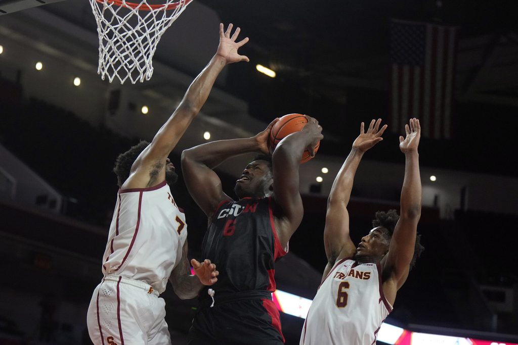Dec 18, 2024; Los Angeles, California, USA; Cal State Northridge Matadors forward Festus Ndumanya (6) shoots the ball against Southern California Trojans guard Wesley Yates III (6)and guard Chibuzo Agbo (7) at Galen Center. Mandatory Credit: Kirby Lee-Imagn Images
