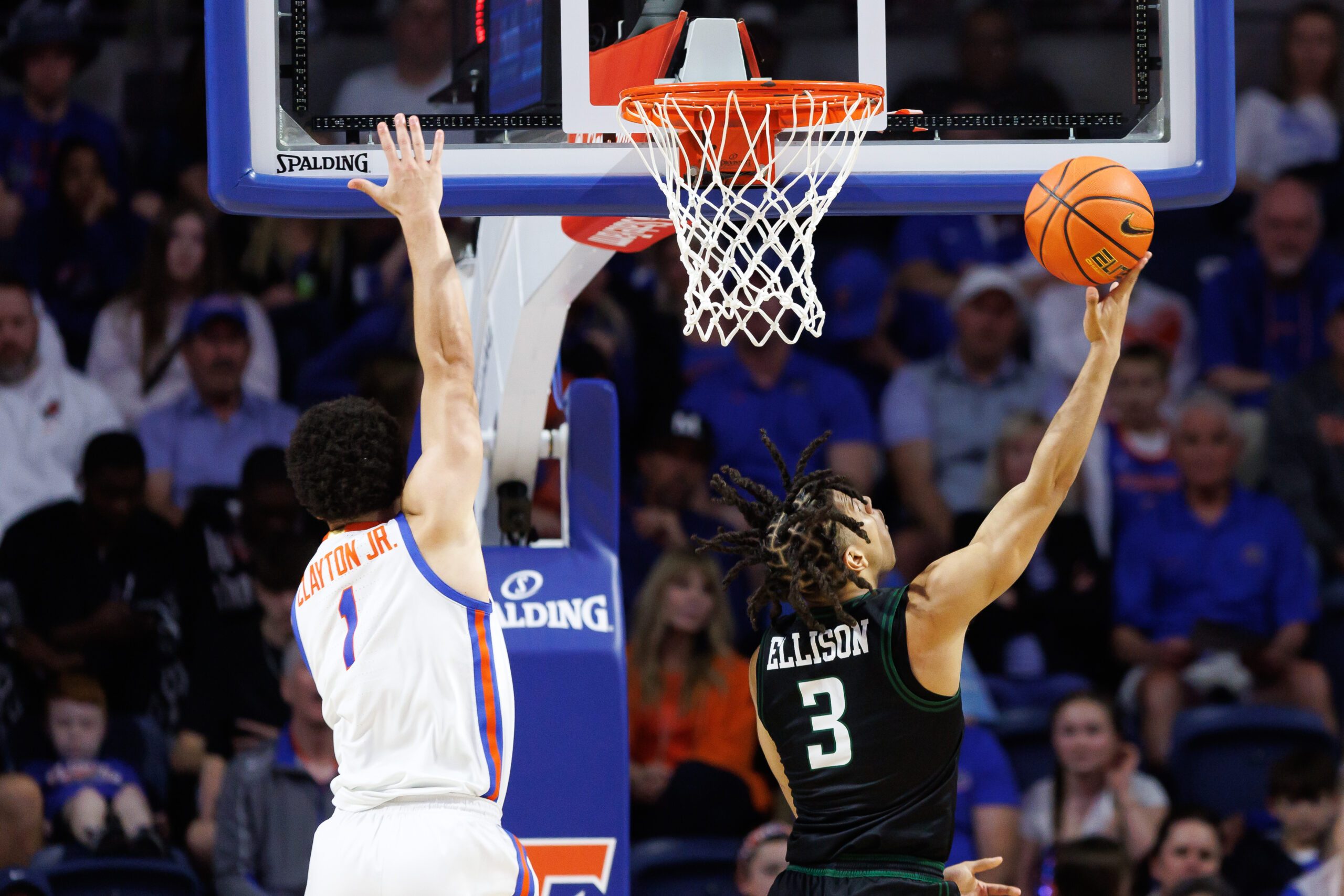 Dec 29, 2024; Gainesville, Florida, USA; Stetson Hatters guard Mehki Ellison (3) makes a layup over Florida Gators guard Walter Clayton Jr. (1) during the second half at Exactech Arena at the Stephen C. O'Connell Center. Mandatory Credit: Matt Pendleton-Imagn Images