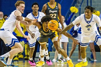 Drexel Dragons forward Lucas Monroe (2) keeps his eyes on a loose ball against Delaware Fightin' Blue Hens guards Christian Ray (5) and Niels Lane (4) during critical late-season CAA basketball game at the Bob Carpenter Center in Newark, Monday, Feb. 26, 2024. Drexel won 70-60.