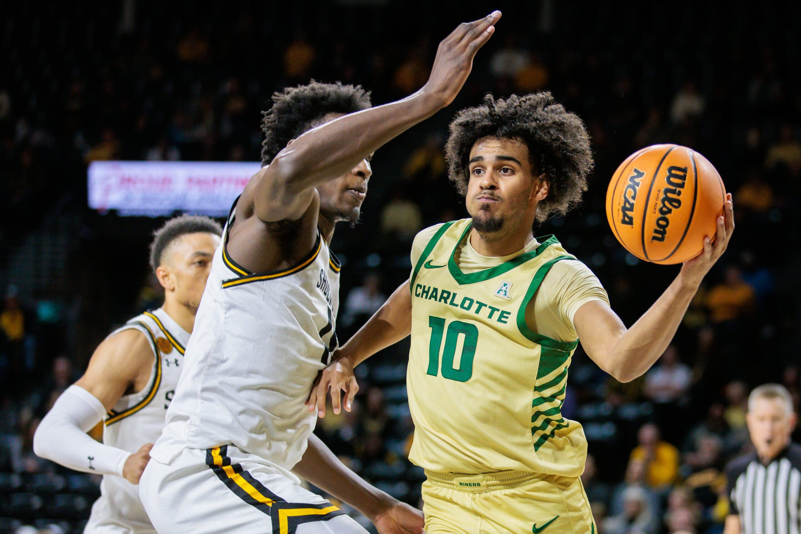 Jan 14, 2025; Wichita, Kansas, USA; Charlotte 49ers guard Nik Graves (10) passes the ball around Wichita State Shockers guard Justin Hill (11) during the first half at Charles Koch Arena. Mandatory Credit: William Purnell-Imagn Images