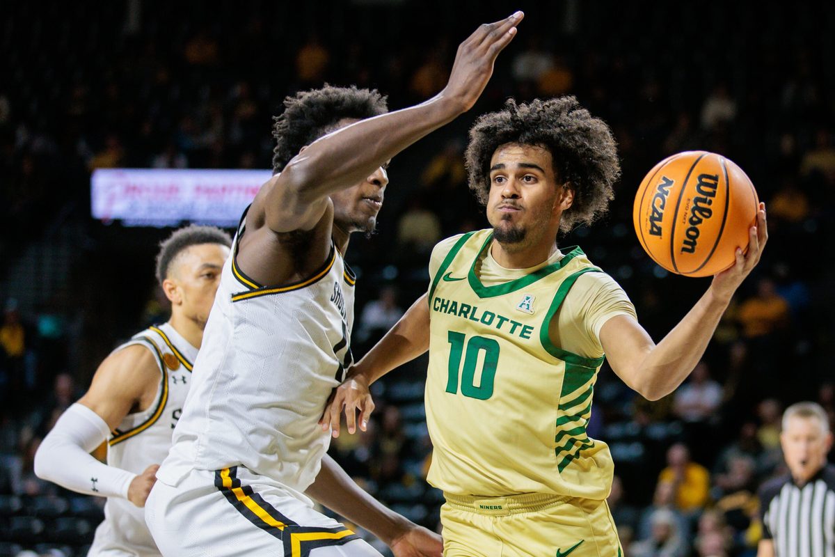 Jan 14, 2025; Wichita, Kansas, USA; Charlotte 49ers guard Nik Graves (10) passes the ball around Wichita State Shockers guard Justin Hill (11) during the first half at Charles Koch Arena. Mandatory Credit: William Purnell-Imagn Images