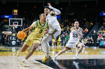 Jan 14, 2025; Wichita, Kansas, USA; Charlotte 49ers guard Ben Bradford (3) drives to the basket around Wichita State Shockers guard Xavier Bell (1) during the first half  at Charles Koch Arena. Mandatory Credit: William Purnell-Imagn Images