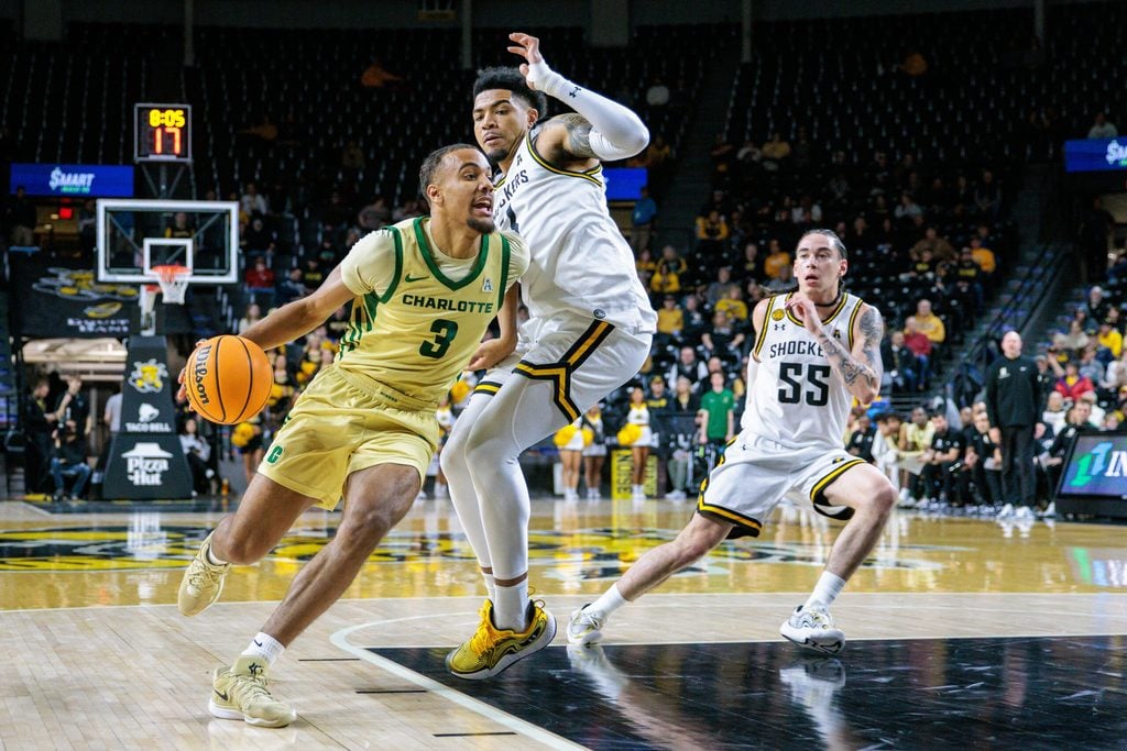 Jan 14, 2025; Wichita, Kansas, USA; Charlotte 49ers guard Ben Bradford (3) drives to the basket around Wichita State Shockers guard Xavier Bell (1) during the first half at Charles Koch Arena. Mandatory Credit: William Purnell-Imagn Images