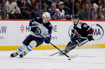 Jan 22, 2025; Denver, Colorado, USA; Winnipeg Jets center Vladislav Namestnikov (7) controls the puck ahead of Colorado Avalanche defenseman Sam Malinski (70) in the second period at Ball Arena. Mandatory Credit: Isaiah J. Downing-Imagn Images