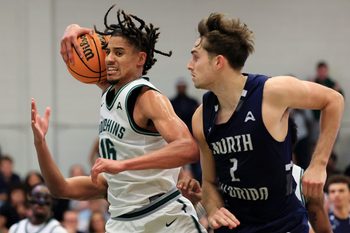 Jacksonville Dolphins forward Zimi Nwokeji (16) grabs a rebound as North Florida Ospreys guard Nate Lliteras (2) looks on during the second half of an NCAA men’s basketball matchup Saturday, Feb. 1, 2025 at Jacksonville University in Jacksonville, Fla. UNF held off a late rally from JU defeating them 81-78. [Corey Perrine/Florida Times-Union]
