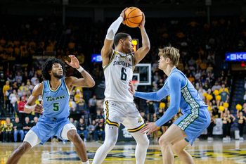 Feb 23, 2025; Wichita, Kansas, USA; Wichita State Shockers forward Corey Washington (6) looks to pass over Tulane Green Wave guard Rowan Brumbaugh (7) during the second half at Charles Koch Arena. Mandatory Credit: William Purnell-Imagn Images