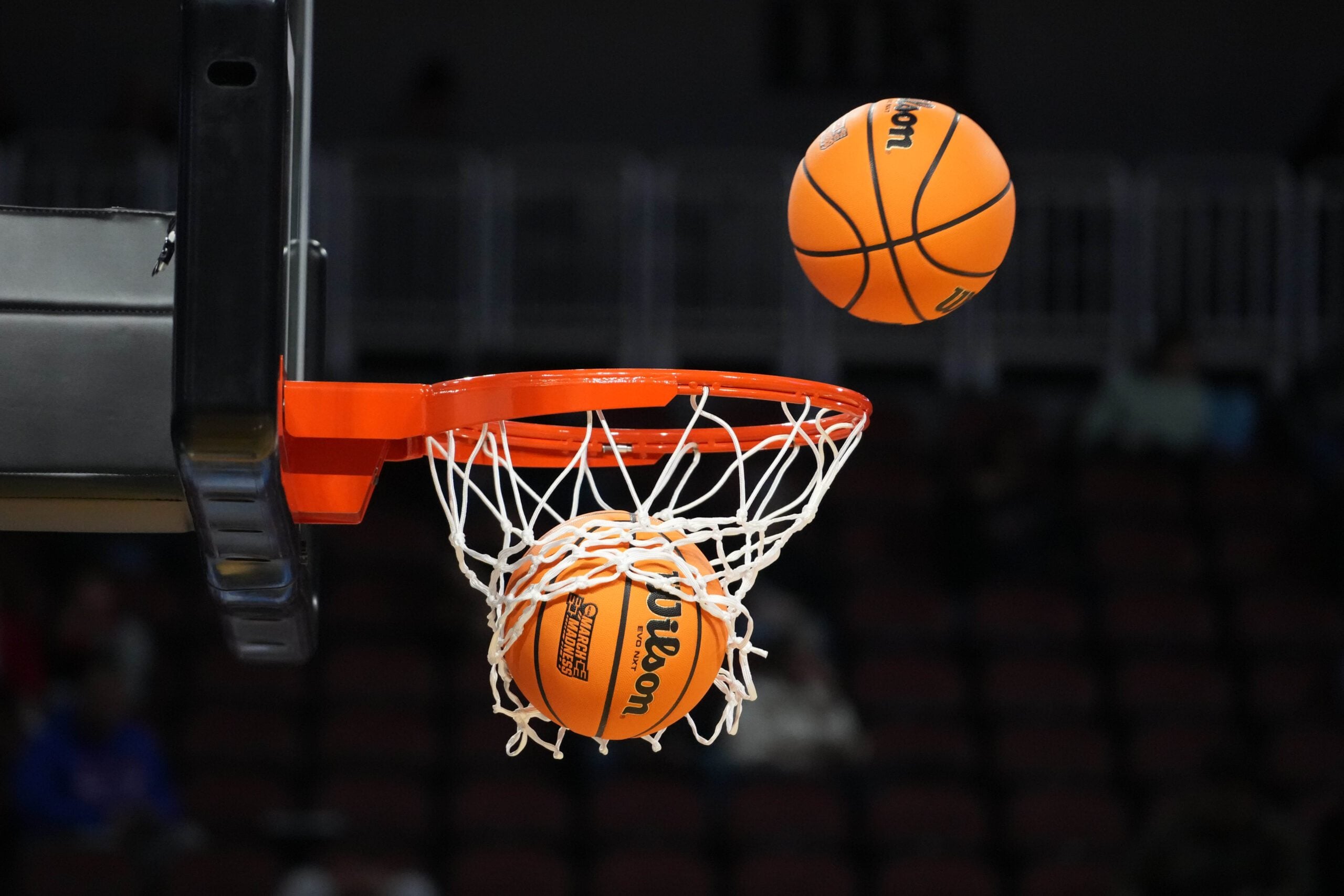 Mar 19, 2025; Wichita, KS, USA; Wilson Evo NXT official basketballs with March Madness logo approach the rim and the net at Intrust Bank Arena. Mandatory Credit: Kirby Lee-Imagn Images