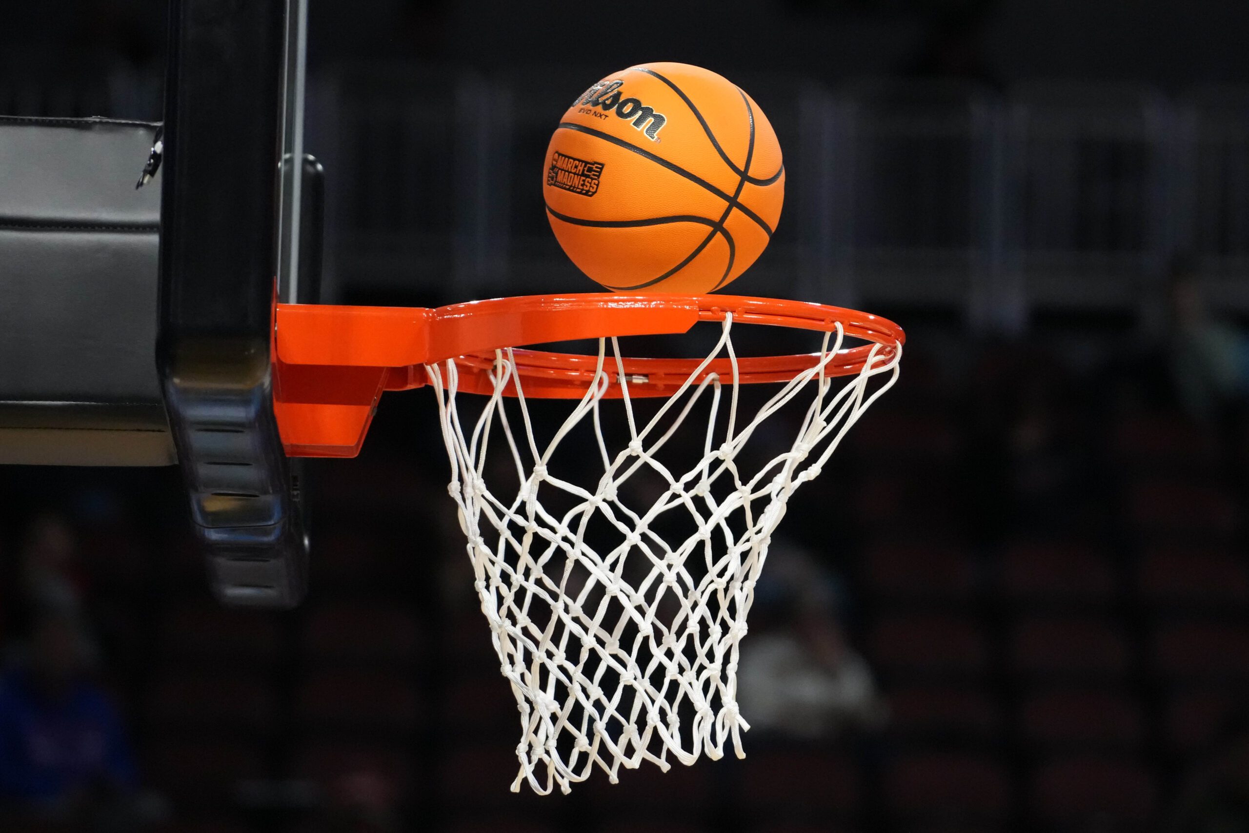 Mar 19, 2025; Wichita, KS, USA; A Wilson Evo NXT official basketball with March Madness logo approaches the rim and the net at Intrust Bank Arena. Mandatory Credit: Kirby Lee-Imagn Images