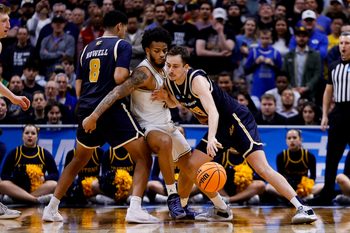 March 20, 2025; Denver, CO, USA; UC San Diego Tritons guard Tyler McGhie (13) dribbles the ball as guard Chris Howell (8) screens and Michigan Wolverines guard Roddy Gayle Jr. (11) defends during the second half at Ball Arena. Mandatory Credit: Isaiah J. Downing-Imagn Images