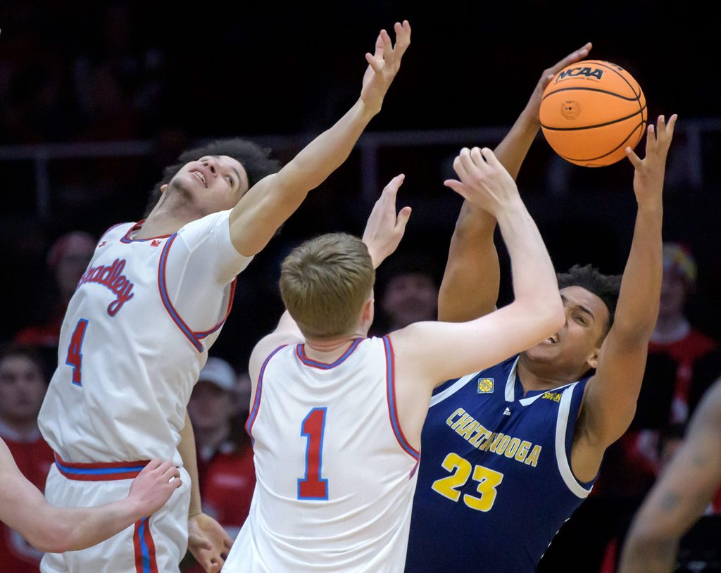 Chattanooga's Latif Diouf, right, pulls in a rebound over Bradley's Corey Thomas, left, and Almar Atlason in the second half of their NIT quarterfinal basketball game Tuesday, March 25, 2025 at Carver Arena in Peoria. The Mocs advanced to the semifinals with a 67-65 win.