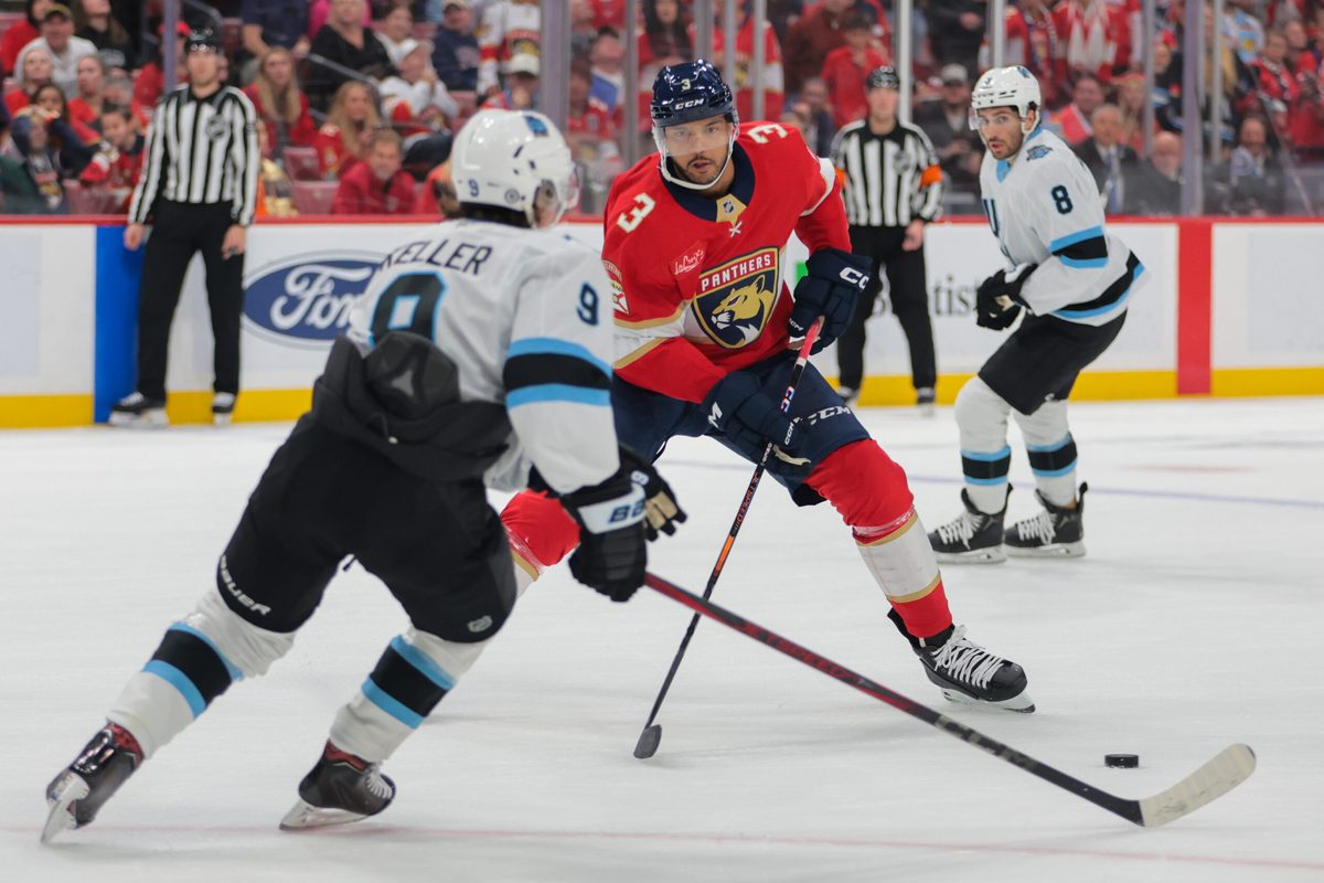Mar 28, 2025; Sunrise, Florida, USA; Florida Panthers defenseman Seth Jones (3) moves the puck as Utah Hockey Club center Clayton Keller (9) defends during overtime at Amerant Bank Arena. Mandatory Credit: Sam Navarro-Imagn Images