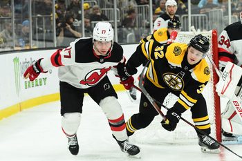Apr 15, 2025; Boston, Massachusetts, USA;  New Jersey Devils defenseman Simon Nemec (17) and Boston Bruins center John Farinacci (32) battle behind the goal during the third period at TD Garden. Mandatory Credit: Bob DeChiara-Imagn Images