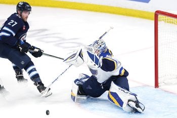 May 4, 2025; Winnipeg, Manitoba, CAN; St. Louis Blues goaltender Jordan Binnington (50) blocks a shot by Winnipeg Jets left wing Nikolaj Ehlers (27) in first overtime in game seven of the first round of the 2025 Stanley Cup Playoffs at Canada Life Centre. Mandatory Credit: James Carey Lauder-Imagn Images