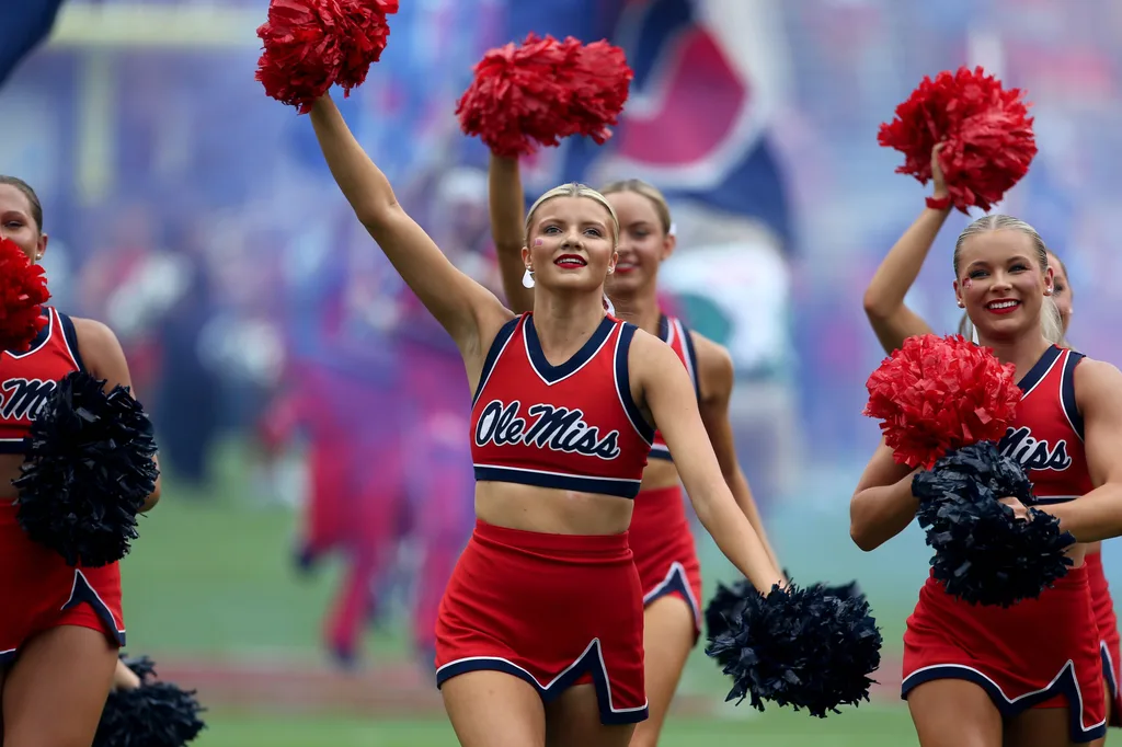 Sep 20, 2025; Oxford, Mississippi, USA; Mississippi Rebels cheerleaders lead the team onto the field prior to the game against the Tulane Green Wave at Vaught-Hemingway Stadium. Mandatory Credit: Petre Thomas-Imagn Images
