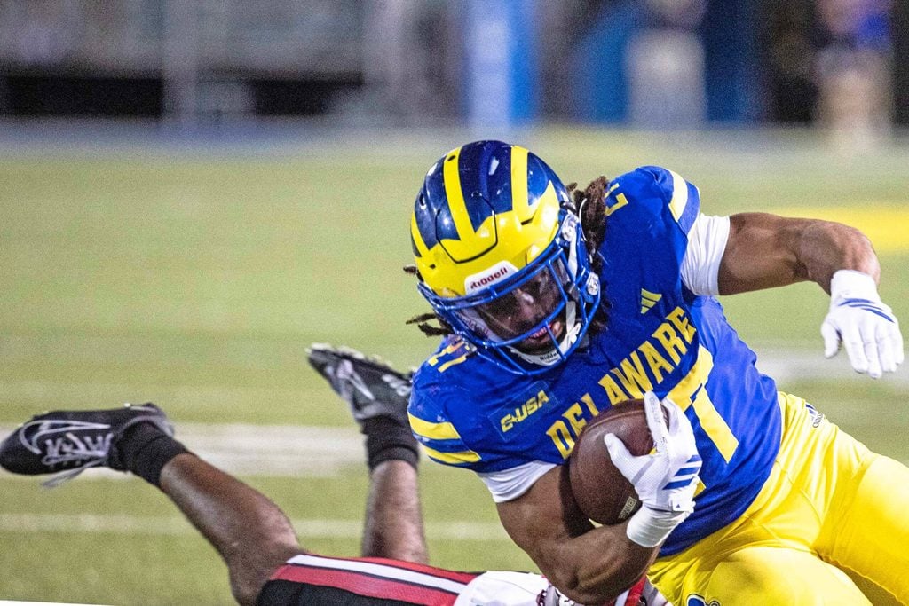 Delaware Blue Hens running back Jo Silver (27) hangs on to the ball as he is taken down by Western Kentucky during Delaware's first home CUSA football game, which was nationally televised, at Delaware Stadium in Newark on Oct. 3, 2025. Western Kentucky won 27-24.