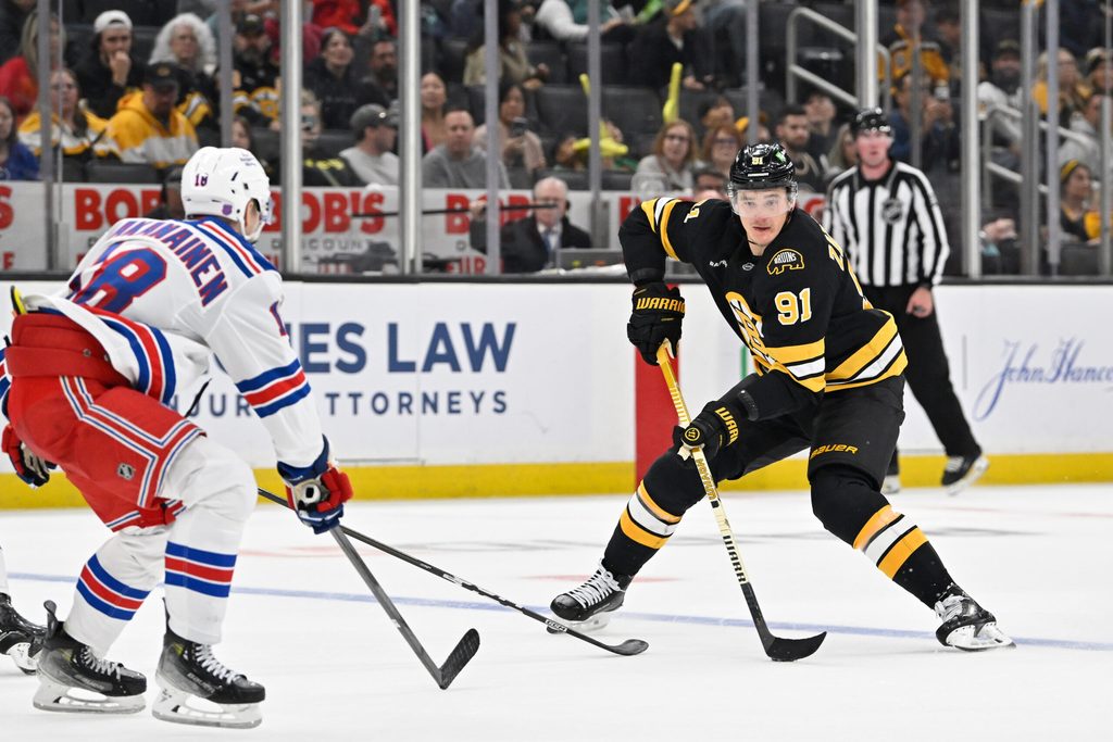 Oct 4, 2025; Boston, Massachusetts, USA; Boston Bruins defenseman Nikita Zadorov (91) plays the puck at the blue line against New York Rangers defenseman Urho Vaakanainen (18) during the third period period at TD Garden. Mandatory Credit: Eric Canha-Imagn Images