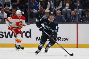 Oct 15, 2025; Salt Lake City, Utah, USA; Utah Mammoth defenseman Dmitri Simashev (26) skates with the puck against the Calgary Flames during the first period at Delta Center. Mandatory Credit: Rob Gray-Imagn Images