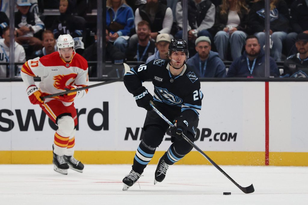 Oct 15, 2025; Salt Lake City, Utah, USA; Utah Mammoth defenseman Dmitri Simashev (26) skates with the puck against the Calgary Flames during the first period at Delta Center. Mandatory Credit: Rob Gray-Imagn Images