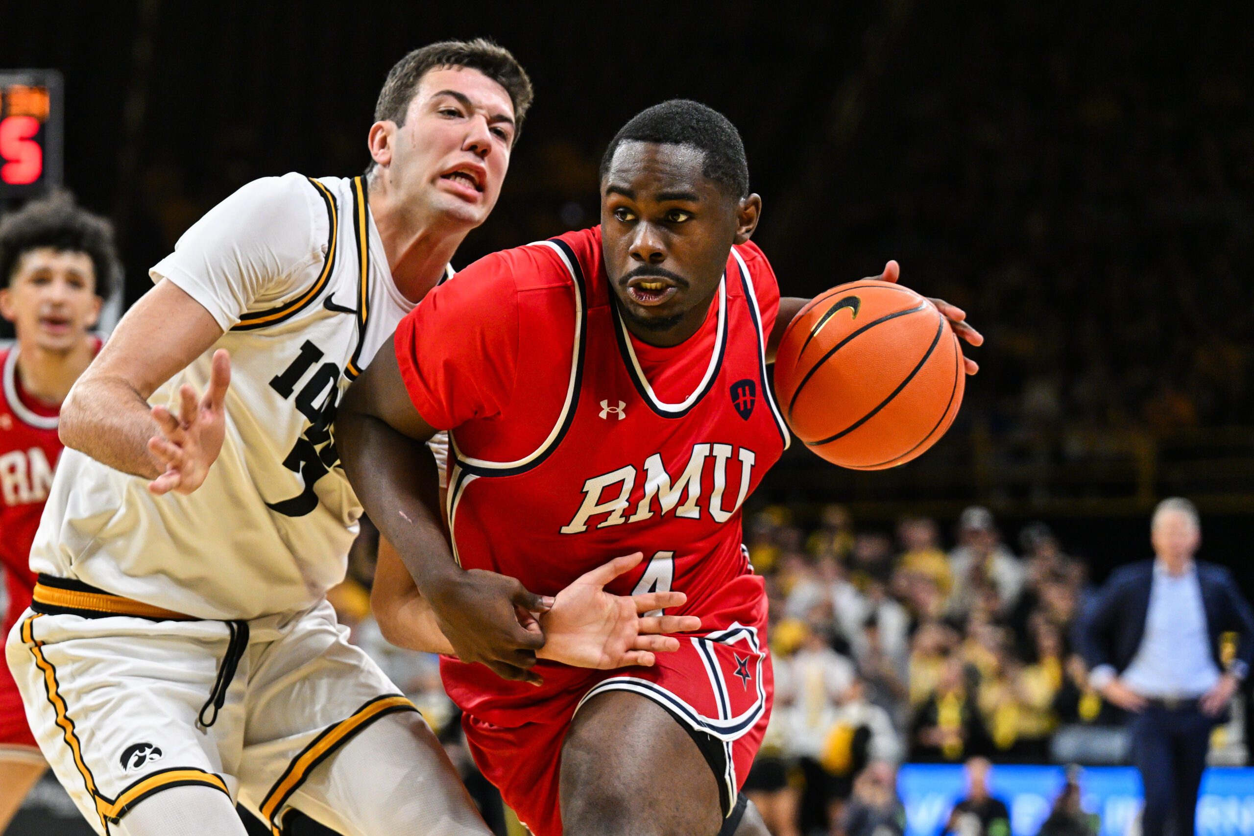 Nov 4, 2025; Iowa City, Iowa, USA; Robert Morris Colonials guard Kaleb Brown (4) goes to the basket as Iowa Hawkeyes forward Alvaro Folgueiras (7) defends during the first half at Carver-Hawkeye Arena. Mandatory Credit: Jeffrey Becker-Imagn Images