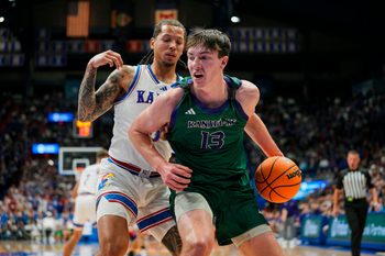 Nov 3, 2025; Lawrence, Kansas, USA; Green Bay Phoenix forward Marcus Hall (13) drives against Kansas Jayhawks guard Tre White (3) during the first half at Allen Fieldhouse. Mandatory Credit: Jay Biggerstaff-Imagn Images