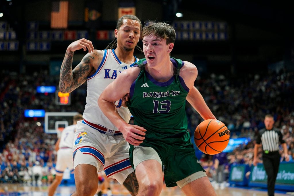 Nov 3, 2025; Lawrence, Kansas, USA; Green Bay Phoenix forward Marcus Hall (13) drives against Kansas Jayhawks guard Tre White (3) during the first half at Allen Fieldhouse. Mandatory Credit: Jay Biggerstaff-Imagn Images