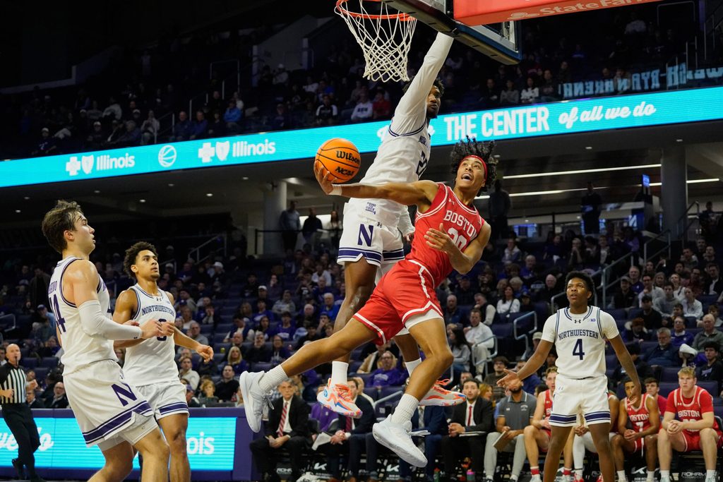 Nov 7, 2025; Evanston, Illinois, USA; Boston University Terriers guard Michael McNair (20) shoots the ball against Northwestern Wildcats forward Arrinten Page (22) (obscured) during the second half at Welsh-Ryan Arena. Mandatory Credit: David Banks-Imagn Images