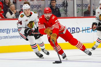 Nov 9, 2025; Detroit, Michigan, USA; Detroit Red Wings center Dylan Larkin (71) handles the puck against Chicago Blackhawks center Colton Dach (34) during the second period at Little Caesars Arena. Mandatory Credit: Brian Bradshaw Sevald-Imagn Images