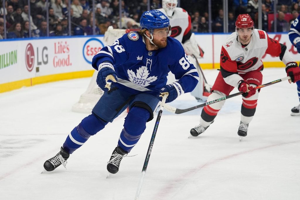 Nov 9, 2025; Toronto, Ontario, CAN; Toronto Maple Leafs forward William Nylander (88) and Carolina Hurricanes defenseman Sean Walker (26) chase after a puck during the first period at Scotiabank Arena. Mandatory Credit: John E. Sokolowski-Imagn Images