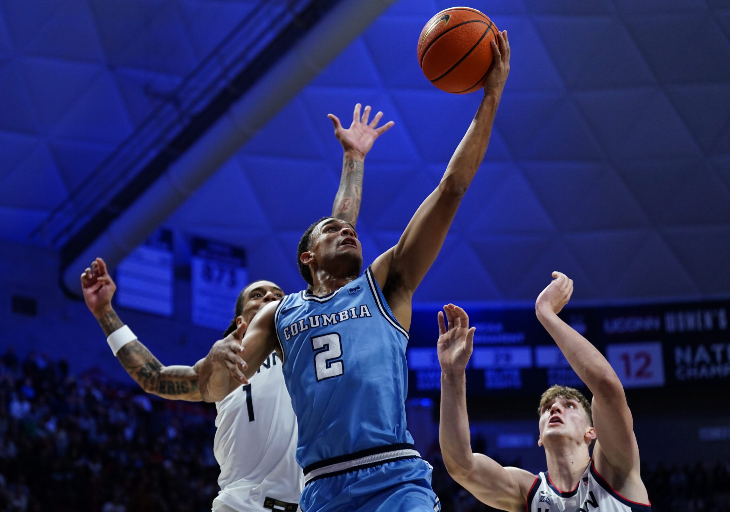 Nov 10, 2025; Storrs, Connecticut, USA; Columbia Lions guard Kenny Noland (2) drives to the basket against UConn Huskies guard Solo Ball (1) and center Eric Reibe (12) in the first half at Harry A. Gampel Pavilion. Mandatory Credit: David Butler II-Imagn Images