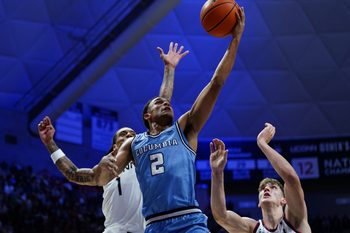 Nov 10, 2025; Storrs, Connecticut, USA; Columbia Lions guard Kenny Noland (2) drives to the basket against UConn Huskies guard Solo Ball (1) and center Eric Reibe (12) in the first half at Harry A. Gampel Pavilion. Mandatory Credit: David Butler II-Imagn Images