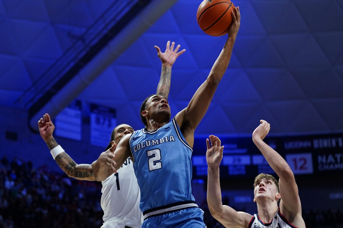 Nov 10, 2025; Storrs, Connecticut, USA; Columbia Lions guard Kenny Noland (2) drives to the basket against UConn Huskies guard Solo Ball (1) and center Eric Reibe (12) in the first half at Harry A. Gampel Pavilion. Mandatory Credit: David Butler II-Imagn Images