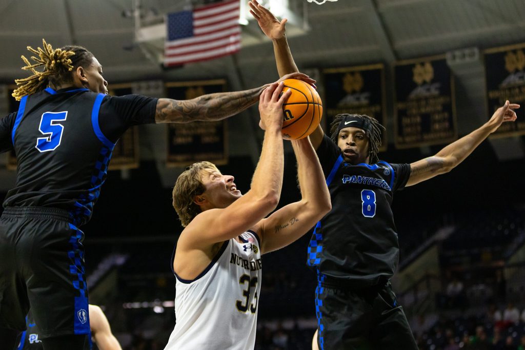 Nov 11, 2025; South Bend, Indiana, USA; Eastern Illinois Panthers guard Zion Fruster (5) blocks Notre Dame Fighting Irish forward Carson Towt (33) as forward Terry McMorris (8) also defends during the second half at Purcell Pavilion at the Joyce Center. Mandatory Credit: Michael Caterina-Imagn Images