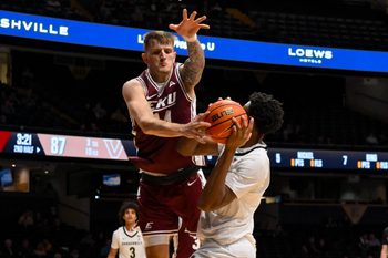 Nov 12, 2025; Nashville, Tennessee, USA;  Eastern Kentucky Colonels forward Austin Ball (14) blocks the shot of  Vanderbilt Commodores forward Ak Okereke (10) during the second half at Memorial Gymnasium. Mandatory Credit: Steve Roberts-Imagn Images