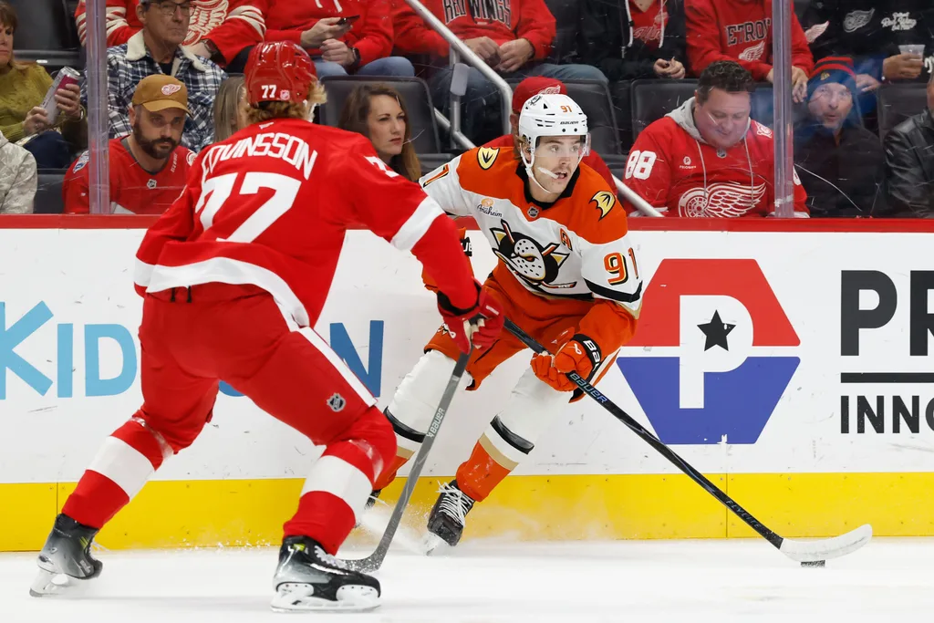 Nov 13, 2025; Detroit, Michigan, USA; Anaheim Ducks center Leo Carlsson (91) skates with the puck defended by Detroit Red Wings defenseman Simon Edvinsson (77) in the first period at Little Caesars Arena. Mandatory Credit: Rick Osentoski-Imagn Images