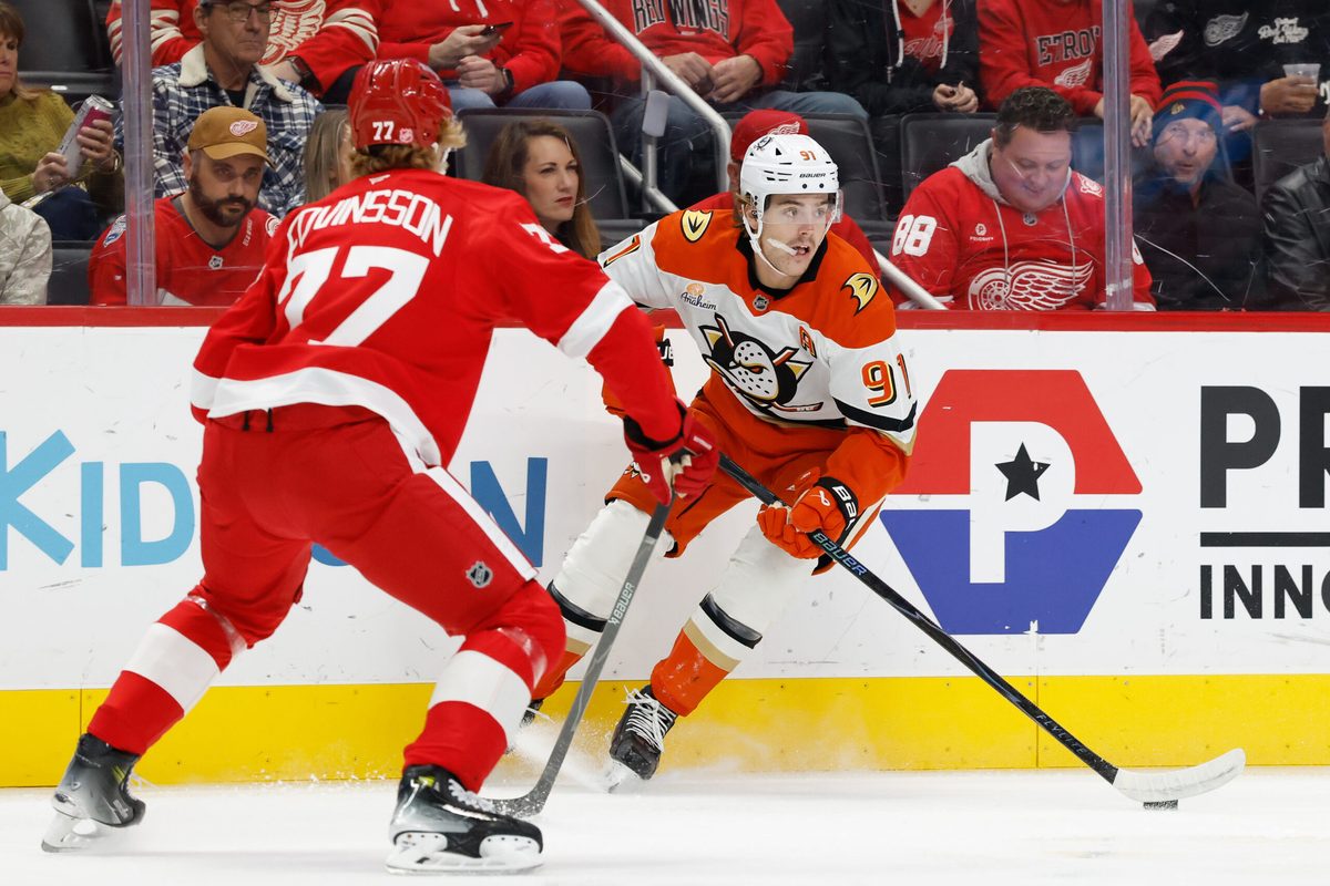 Nov 13, 2025; Detroit, Michigan, USA; Anaheim Ducks center Leo Carlsson (91) skates with the puck defended by Detroit Red Wings defenseman Simon Edvinsson (77) in the first period at Little Caesars Arena. Mandatory Credit: Rick Osentoski-Imagn Images