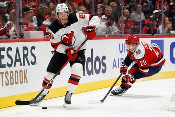 Nov 15, 2025; Washington, District of Columbia, USA; New Jersey Devils center Dawson Mercer (91) skates with the puck against as Washington Capitals center Hendrix Lapierre (29) chases during the third period at Capital One Arena. Mandatory Credit: Geoff Burke-Imagn Images