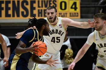 Nov 16, 2025; West Lafayette, Indiana, USA; Akron Zips guard Evan Mahaffey (12) looks to get past Purdue Boilermakers center Oscar Cluff (45) during the second half at Mackey Arena. Mandatory Credit: Marc Lebryk-Imagn Images