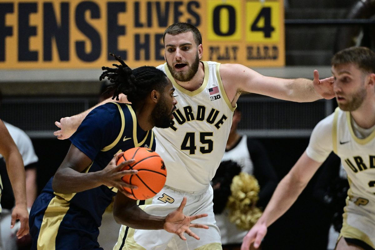 Nov 16, 2025; West Lafayette, Indiana, USA; Akron Zips guard Evan Mahaffey (12) looks to get past Purdue Boilermakers center Oscar Cluff (45) during the second half at Mackey Arena. Mandatory Credit: Marc Lebryk-Imagn Images