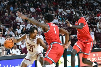 NMSU's Jemel Jones looks to make a pass to a teammate along the baseline as the Aggies took on the Lobos on Saturday night in Las Cruces.